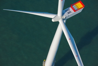 shot of the top of a wind turbine with a still sea below