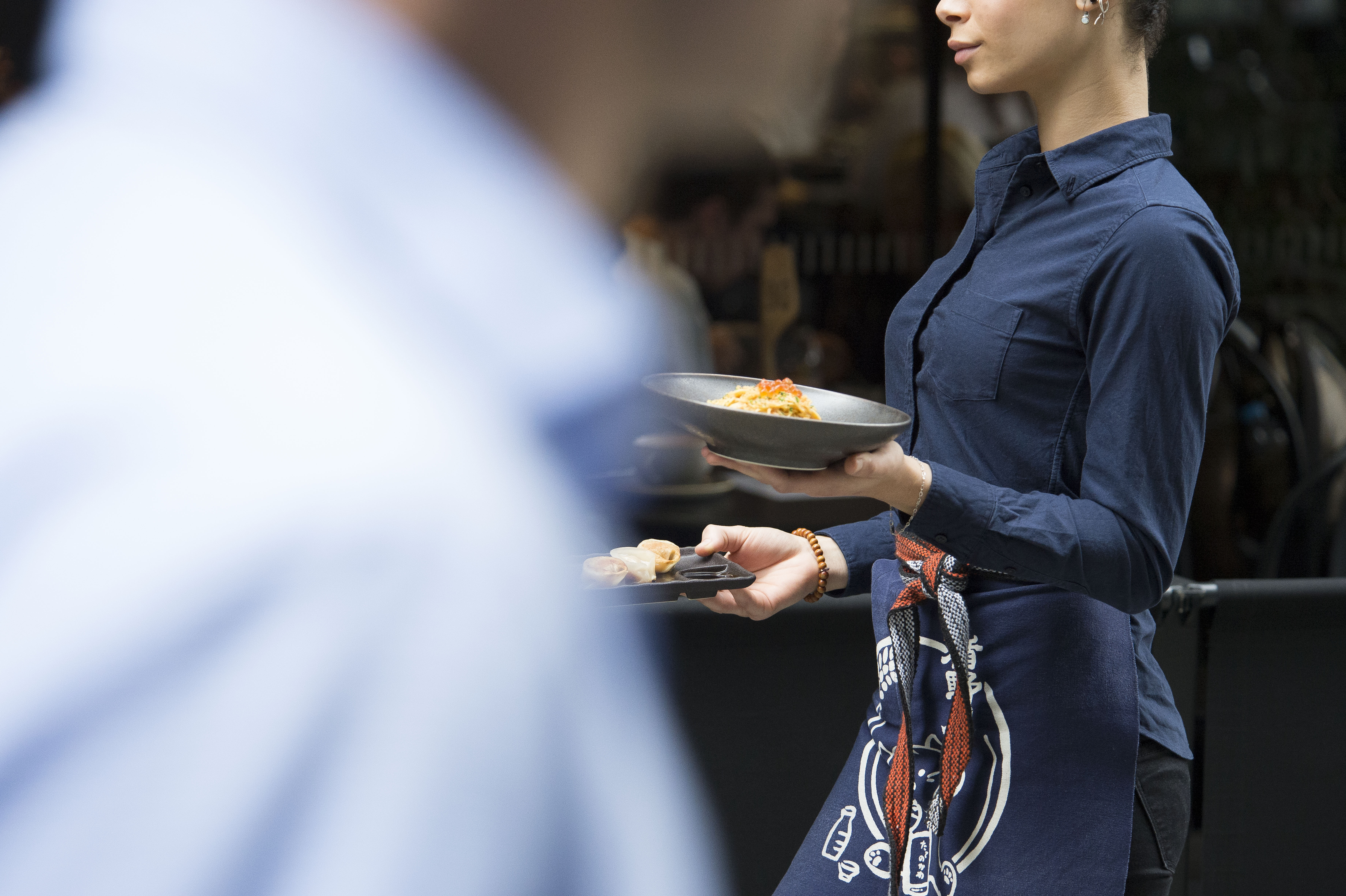 waitress bringing a plate of food to customers