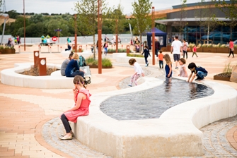 kids playing with a small water feature outside of the lakeside retail park