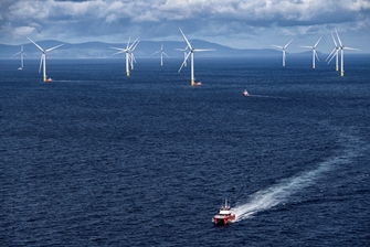 Photo of windfarm, with boat in foreground